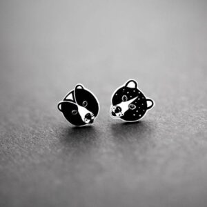 Karud Kõrvarõngad: small black and white bear face stud earrings rest on a matt grey surface, highlighting curated Estonian design—ideal for discovering unique Tallinn shopping treasures. Gate21.ee