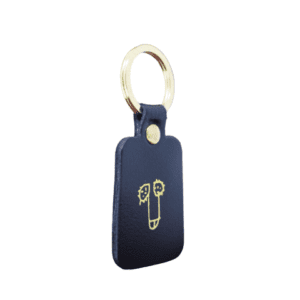 A rectangular red leather Dick Key Ring with a gold metal ring and a simple gold line drawing—an ideal choice for Tallinn shopping or discovering unique ideas at your favourite gift shop. Gate21.ee