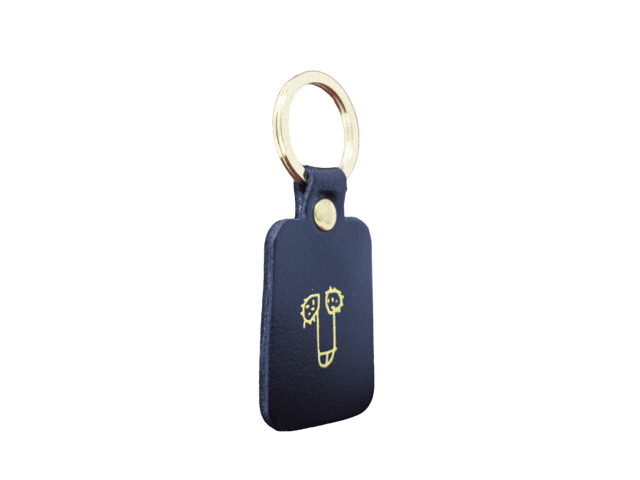 A rectangular red leather Dick Key Ring with a gold metal ring and a simple gold line drawing—an ideal choice for Tallinn shopping or discovering unique ideas at your favourite gift shop. Gate21.ee
