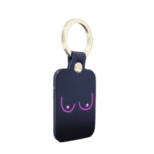 The Boob Key Ring - Black is a rectangular black leather keyring with a gold keyring. It features a minimalist pink line drawing of breasts accented by small white dots for nipples, ideal for concept shops or Tallinn shoppers. Gate21.ee