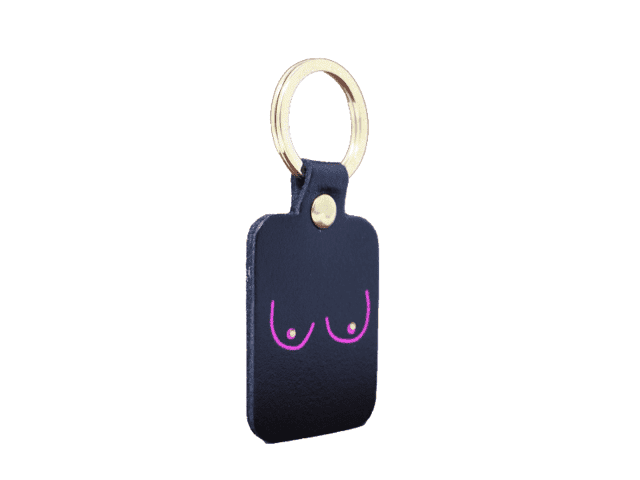 The Boob Key Ring - Black is a rectangular black leather keyring with a gold keyring. It features a minimalist pink line drawing of breasts accented by small white dots for nipples, ideal for concept shops or Tallinn shoppers. Gate21.ee
