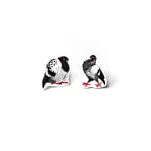 Öökullid Kõrvarõngad are illustrated pigeon-shaped badges in black, white, and grey with bold red eyes and feet—displayed on a white background, they're perfect for bringing quirky flair to your gift shop or concept store. Gate21.ee