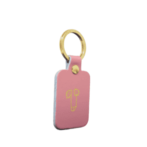 A rectangular red Dick Key Ring with a gold ring and rivet, featuring a simple yellow line drawing of a pencil with two leaves—an elegant piece of curated Estonian design. Gate21.ee