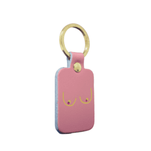 The Boob Key Ring - Black is a rectangular keyring with a gold metal ring and a minimalist line drawing of two breasts on the front—an ideal quirky find for any curated gift shop. Gate21.ee