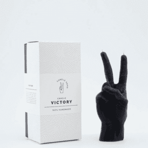 A black candle sculpted in the shape of a hand making a peace sign stands upright next to a white box labelled Victory Candle Hand, 100% Handmade—a curated piece with minimalist style, perfect for any gift shop featuring Estonian design. Gate21.ee