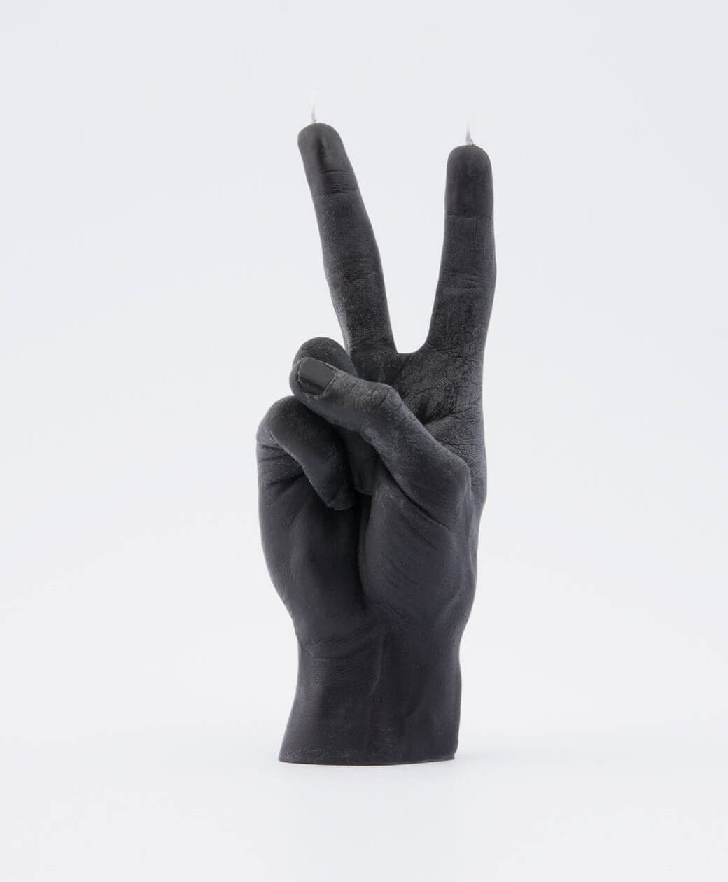 A black candle shaped like a human hand making a peace sign, with wicks at the raised fingers—an eye-catching piece of Estonian design, perfect for those seeking unique ideas or browsing your favourite gift shop. Gate21.ee
