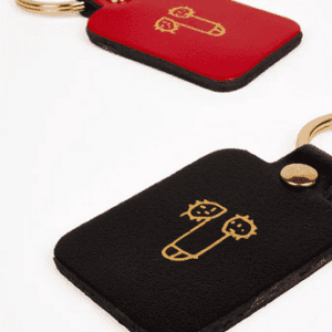 A black leather keyring named "Dick Key Ring" features a gold metal ring and an abstract gold line drawing—ideal for Tallinn shopping or as a thoughtful present. Gate21.ee