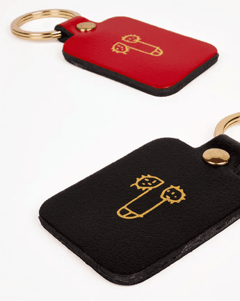 A black leather keyring named "Dick Key Ring" features a gold metal ring and an abstract gold line drawing—ideal for Tallinn shopping or as a thoughtful present. Gate21.ee