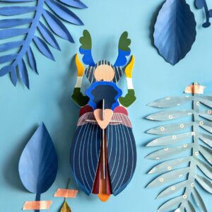 A curated Giant Lobster paper model with vibrant blue, green, and yellow details is centred on a blue background, surrounded by various blue and green paper leaves—showcasing playful Estonian design. Gate21.ee