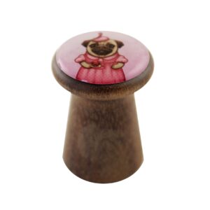 A curated wooden knob with a round top featuring an illustration of a pug in a pink dress and hat, set against a white background&mdash;perfect for those seeking unique ideas or souvenirs from Tallinn shopping. Gate21.ee