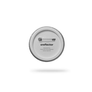The Double - Red button badge is shown from the back, displaying a metal safety pin fastening. The text "oreflector," the designer&rsquo;s name, and website highlight Estonian design on a plain white background. Gate21.ee