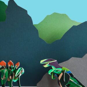 The T-Rex papercraft set features a striking dinosaur with an open mouth in front of layered paper mountains, while three dinosaurs gather in the background—an Estonian-inspired design perfect for gift shop displays. Gate21.ee
