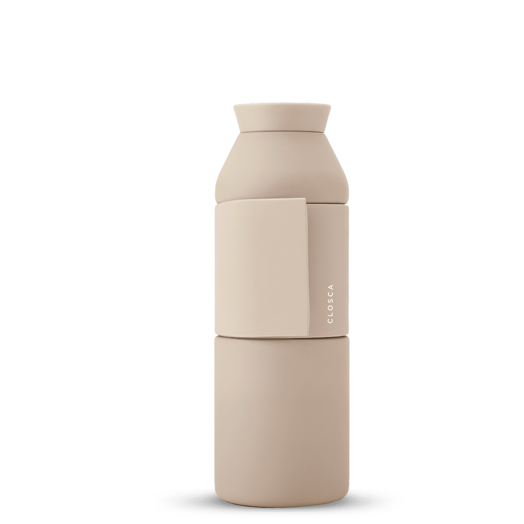 The Closca Wave - Sahara is a beige, cylindrical water bottle with a matte finish and a detachable cup section—ideal for unique gift ideas. "CLOSCA" is printed vertically on the side against a plain white background. Gate21.ee