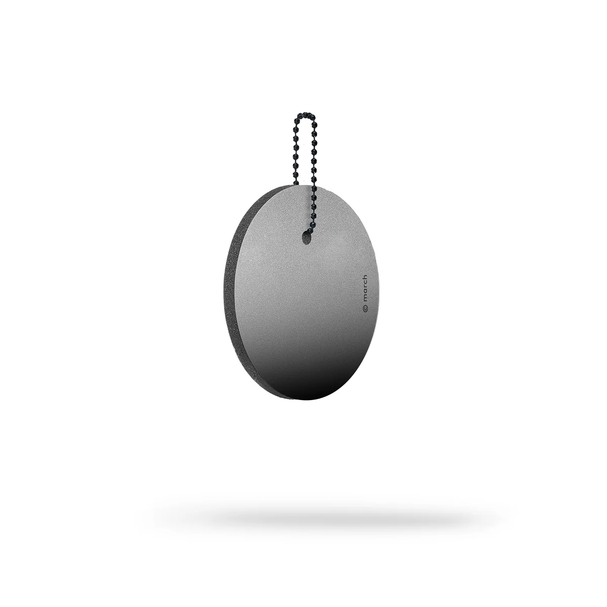 The Dangle - Round - Black Fade is a round, flat reflector with a thin edge and a subtle black fade. A small chain is attached at the top, and the product appears suspended above a white background with a faint shadow below. Gate21.ee