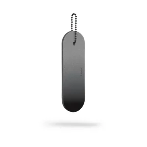 A Dangle – Long – Black Fade reflector, oval-shaped with a smooth black surface and rounded edges, hangs suspended by a small metal ball chain against a white background with a faint shadow below. Gate21.ee