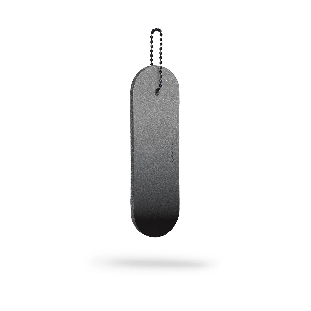 A Dangle &ndash; Long &ndash; Black Fade reflector, oval-shaped with a smooth black surface and rounded edges, hangs suspended by a small metal ball chain against a white background with a faint shadow below. Gate21.ee