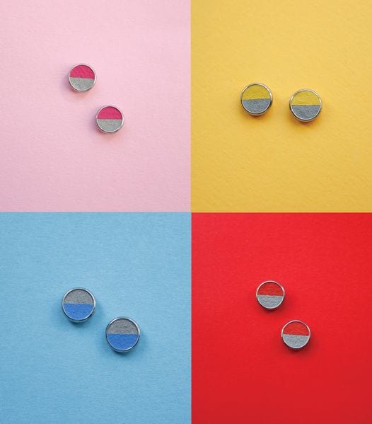 Four pairs of ROUNDS - Concrete - KÕIK stud earrings, inspired by Estonian design, are displayed on pink, yellow, blue, and red backgrounds. Each pair has two-toned halves—one side matching the background and one contrasting for standout style. Gate21.ee