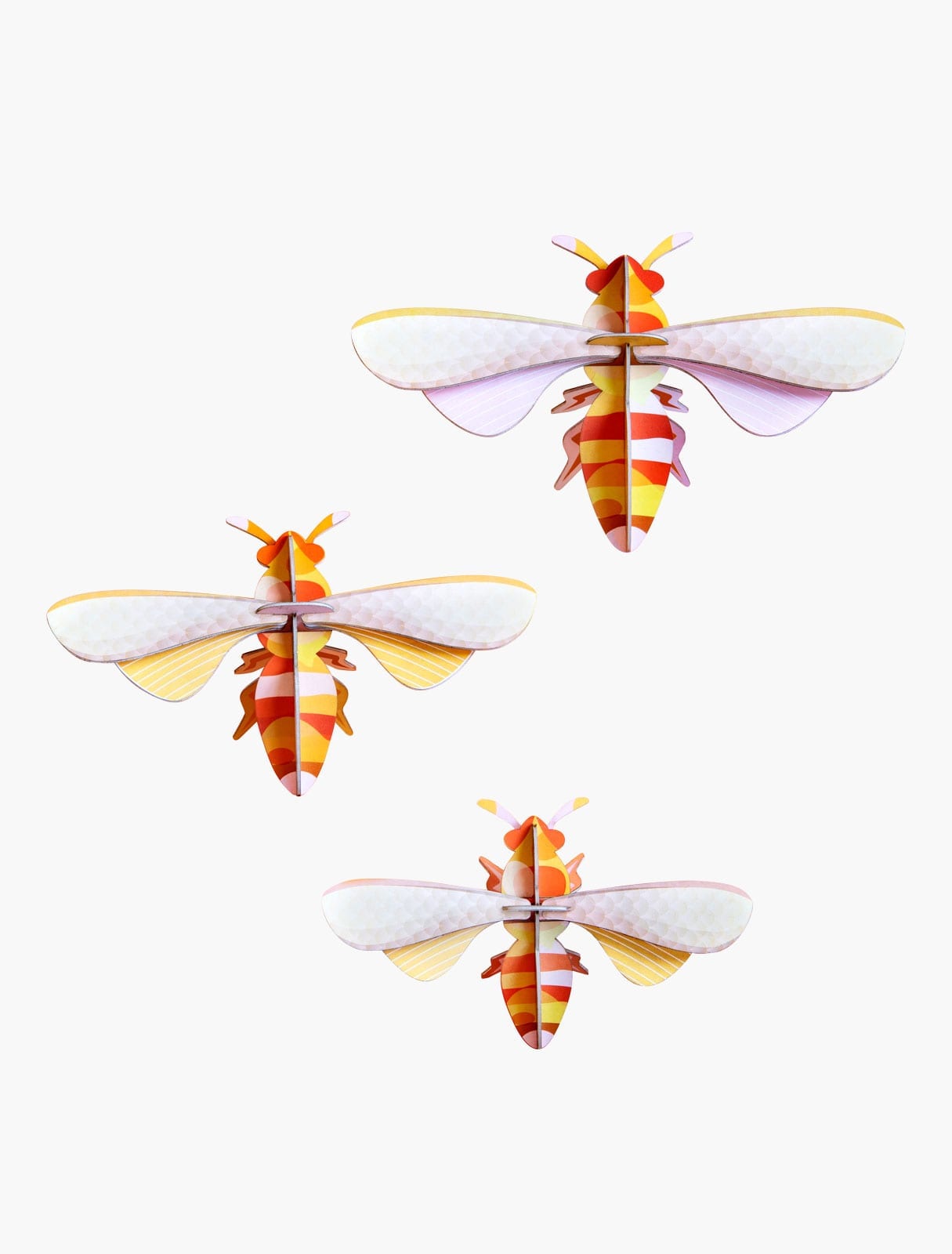 Three curated paper craft bees with orange, yellow, and white striped bodies and pale translucent wings are arranged on a plain white background, reflecting playful Estonian design. Gate21.ee