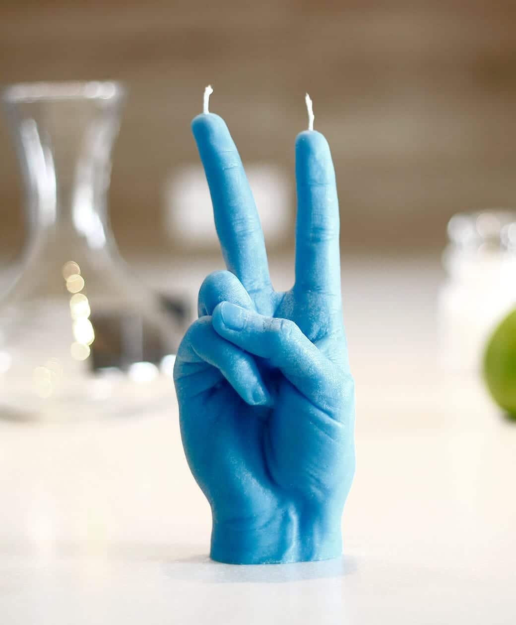 The Peace Candle - Blue is a candle shaped like a human hand making a peace sign, designed by Estonian talent. Featuring two wicks at the fingertips, it’s an eye-catching accent piece for any space. Gate21.ee