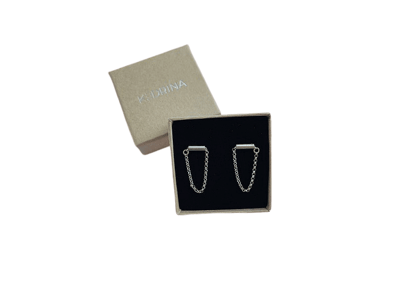A pair of Insomnia - Small - Flat Silver chain earrings displayed in a black velvet-lined jewellery box with a beige lid behind, featuring the KATERINA brand. Explore unique Estonian design ideas at our gift shop. Gate21.ee