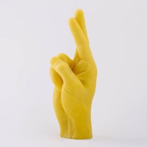 Fingers Crossed - Yellow: A unique Estonian-designed candle shaped like a yellow human hand with crossed index and middle fingers, shown on a plain white background. Gate21.ee