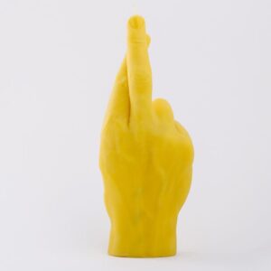 Fingers Crossed - Yellow: a candle shaped like a human hand with crossed index and middle fingers, ideal for curated gift shops or Tallinn shopping, shown against a plain white background. Gate21.ee