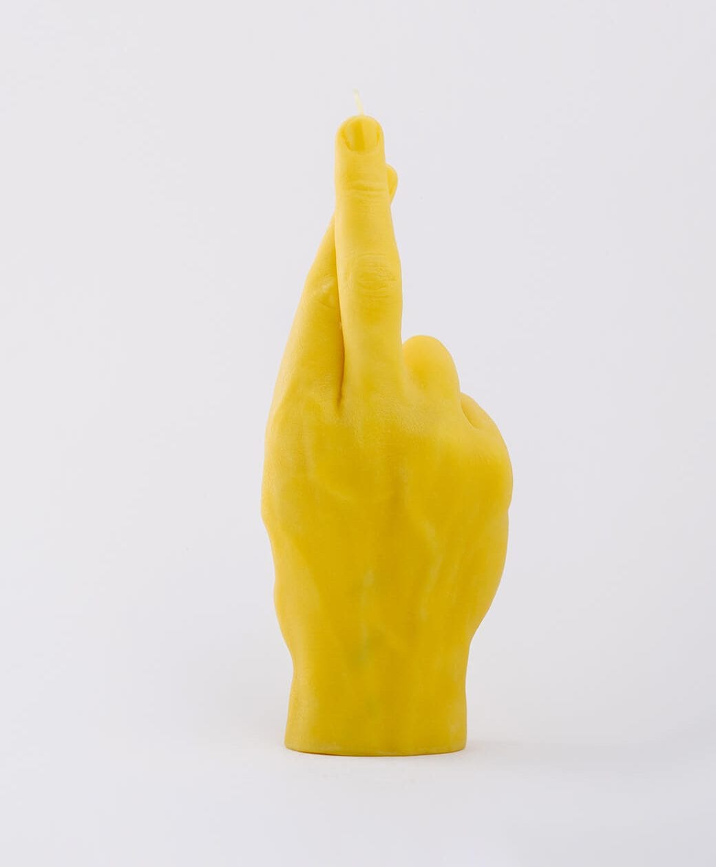 Fingers Crossed - Yellow: a candle shaped like a human hand with crossed index and middle fingers, ideal for curated gift shops or Tallinn shopping, shown against a plain white background. Gate21.ee