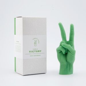 The Peace Candle – Green, shaped like a hand making a peace sign, sits beside its Victory Candle 100% Handmade box, highlighting curated Estonian design on a white background. Gate21.ee