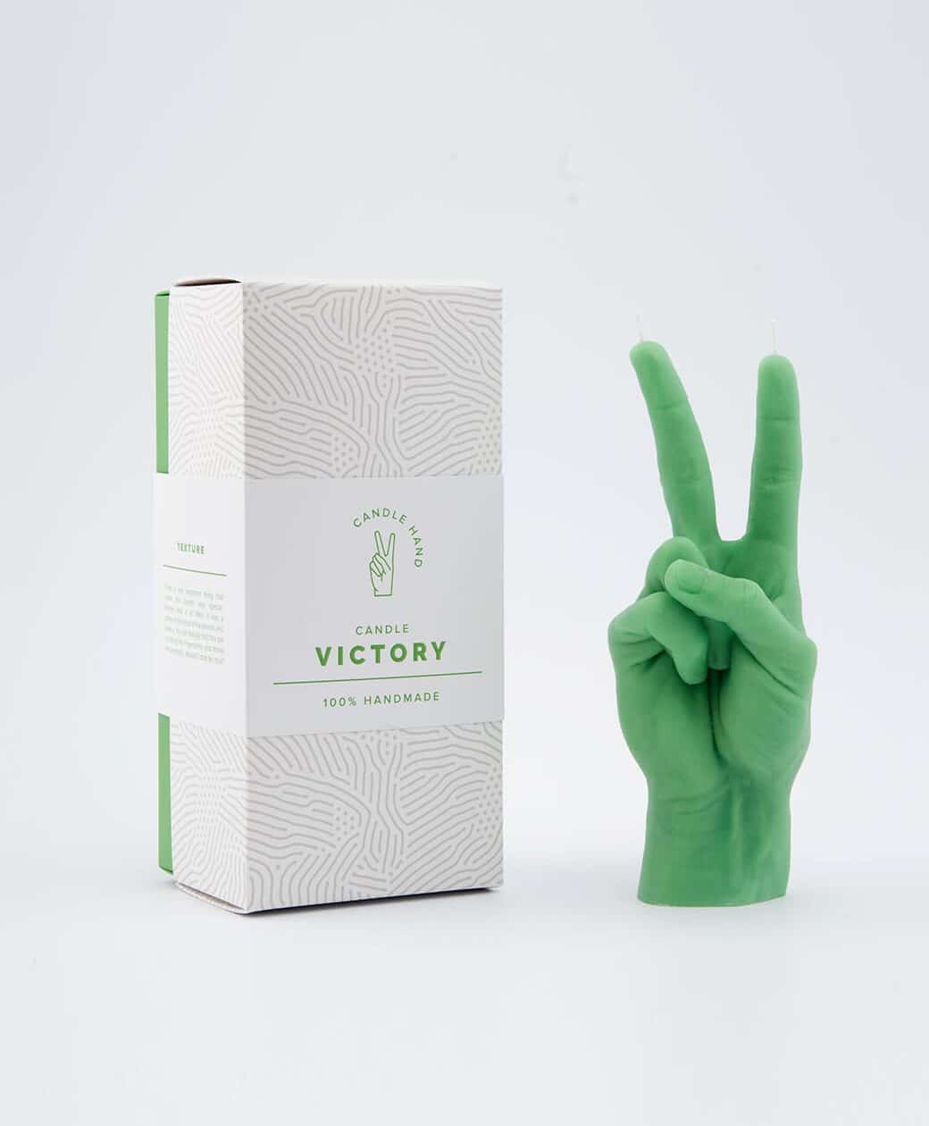 The Peace Candle – Green, shaped like a hand making a peace sign, sits beside its Victory Candle 100% Handmade box, highlighting curated Estonian design on a white background. Gate21.ee