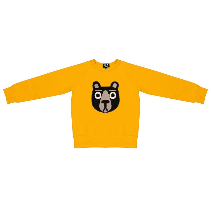 The Kids Bear sweatshirt is a yellow long-sleeve top with a black and white bear face graphic and a small MLP logo on the collar tag, inspired by Estonian design—ideal for unique style from a concept shop. Gate21.ee