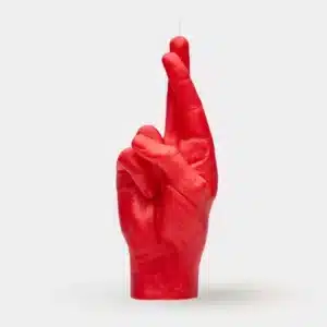 Fingers Crossed - Red is a striking red sculpture of a human hand with crossed fingers, standing upright against a plain light grey background—an ideal piece for fans of curated Estonian design and Tallinn shopping. Gate21.ee
