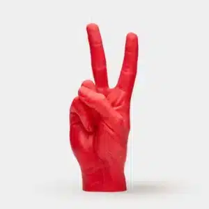 The Peace Candle - Red is shaped like a human hand making a peace sign, with fingertip wicks. Set against a white background, it’s a unique find ideal for anyone looking for creative gifts at concept shops. Gate21.ee