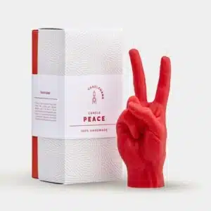 The Peace Candle – Red, shaped like a hand making a peace sign, comes in a white box with red accents and "PEACE" on the label—an ideal way to add curated Estonian design to your gift shop selection. Gate21.ee