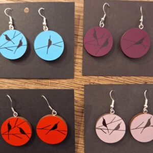 Four pairs of PIPPIN BIRD earrings with bird silhouettes on branches, each on a black square card. Available in blue, maroon, red, and light pink&mdash;great for Tallinn shopping or finding unique gifts at concept shops. Gate21.ee