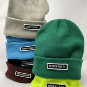 A stack of five NOFUCKSGIVEN - Unisex Beanies - K&Otilde;IK in grey, blue, maroon, green, and neon yellow&mdash;each with a black and white label. Perfect for Tallinn shoppers or anyone after unique style ideas. Gate21.ee