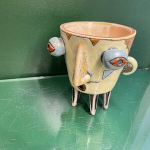 The Tass nagu + others by KAURI KALLAS is a ceramic cup inspired by Estonian design, featuring four legs, blue eyes, and a pointed nose. Decorated with colourful abstract patterns, it&rsquo;s ideal for curated concept shops. Gate21.ee