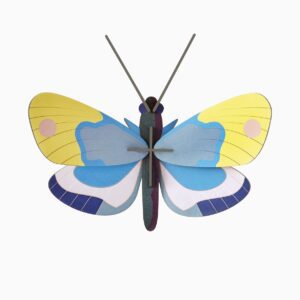 The Yellow Monarch Butterfly features a flat, stylised design with yellow and blue wings, pink spots, and grey antennae—ideal for concept stores wanting unique geometric shapes and symmetrical patterns in blue, purple, and white. Gate21.ee