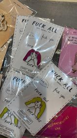 Krõõt Kukkur Pins – KÕIK features illustrated cards in plastic sleeves with bold text (including profanity) and drawings of women with different hair colours and gestures. Ideal for unique gift ideas when shopping in Tallinn or at a trendy concept shop. Gate21.ee