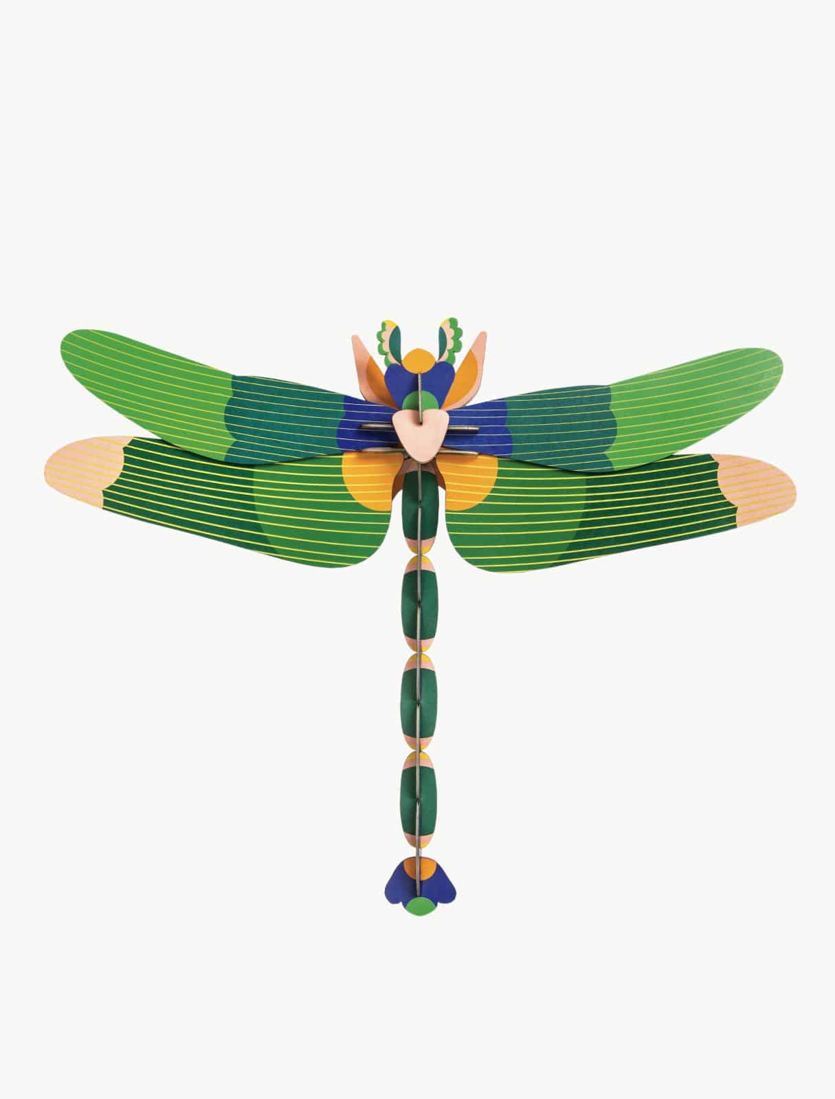The Giant Green Dragonfly is a symmetrical, stylised model made from flat, interlocking green, blue, and beige pieces—showcasing unique Estonian design—displayed on a plain white background. Gate21.ee