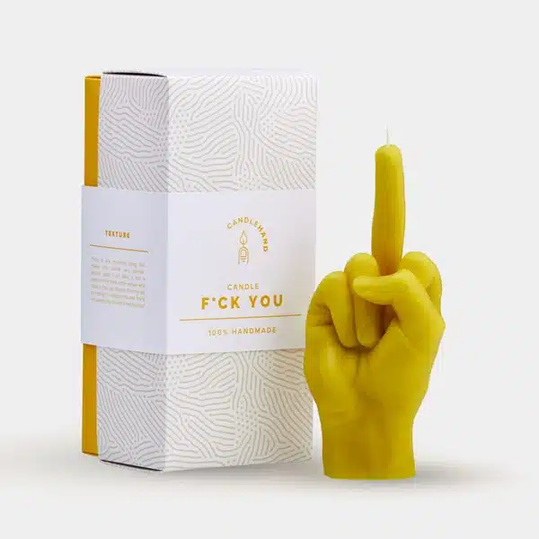 The F*ck You Candle - Yellow is a hand-shaped candle with the middle finger raised, packaged in a white box—an edgy handmade gift perfect for quirky Tallinn shops or anyone seeking something unique. Gate21.ee