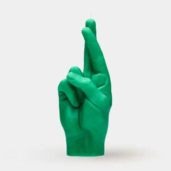 Fingers Crossed - Green: a unique candle shaped like a human hand with crossed fingers, inspired by Estonian design and perfect for concept shops or gift shops. Stands upright against a plain white background. Gate21.ee