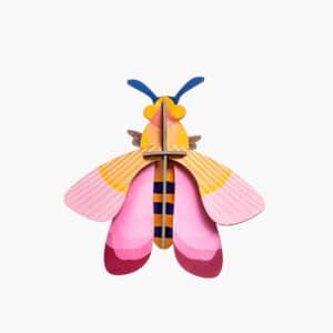 The Pink Bee features pink, yellow, and orange wings, a striped yellow and blue body, blue antennae, and a symmetrical design—perfect for adding curated charm to any gift shop or Tallinn shopping adventure. Gate21.ee