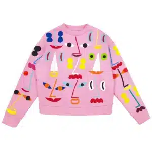 The Pink - Pusa is a pink sweatshirt with a vibrant abstract pattern of geometric faces, featuring colourful eyes, noses, and mouths—a standout gift shop pick or unique fashion choice. Gate21.ee