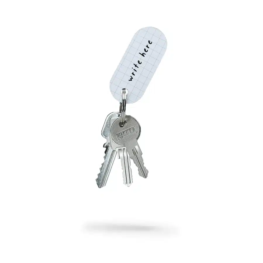 The Reflective Tag - Metallic Silver features three silver keys on a metal ring, attached to a white, grid-patterned label with “write here” text—a standout piece of Estonian design for concept shops or creative displays. Gate21.ee