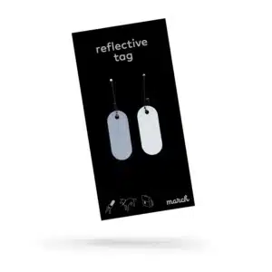 A black package labelled "Reflective Tag - Metallic Silver" holds two silver oval tags on small chains. Person, dog, and bicycle icons plus the march brand logo appear at the bottom—great for Tallinn shopping or as a standout Estonian gift. Gate21.ee