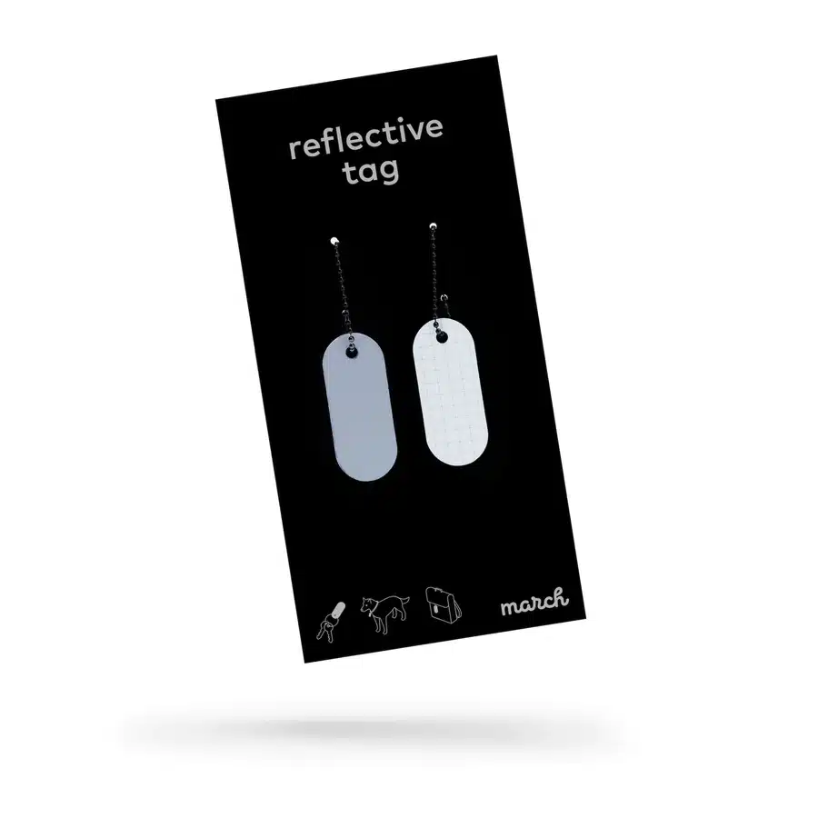 A black package labelled "Reflective Tag - Metallic Silver" holds two silver oval tags on small chains. Person, dog, and bicycle icons plus the march brand logo appear at the bottom&mdash;great for Tallinn shopping or as a standout Estonian gift. Gate21.ee