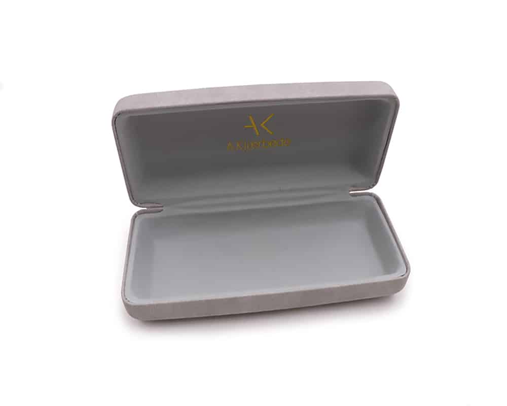 A. Kjaerbede - Sunglasses Case: A grey rectangular case with a hinged lid is open to reveal an empty interior. The inside of the lid displays a gold logo and text, echoing unique Estonian-inspired design ideas. Gate21.ee