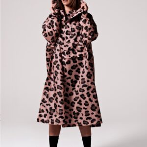A person models the Pink Panther—a long, loose-fitting, pink and black leopard print hooded coat—paired with dark sunglasses and black ankle boots against a plain white background. Gate21.ee
