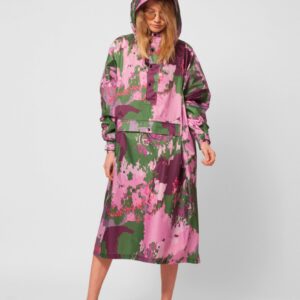 Wearing the Digi Spring hooded long-sleeve dress with a pink, purple, and green abstract floral pattern, a person stands against a plain white background—perfect inspiration for unique Tallinn shopping or your local gift shop. Light open-toe heels complete the look. Gate21.ee
