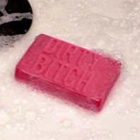 A pink DIRTY BITCH - Soap bar sits on a bubbly surface, making it a fun and unique gift shop find for anyone seeking something different. Gate21.ee